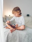 Netter Junge mit digitalem Tablet auf dem Sofa — Stockfoto