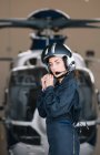 Piloto niña posa con su helicóptero y casco - foto de stock