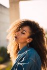 Elegante giovane donna afroamericana in camicia di jeans con gli occhi chiusi alla luce del sole — Foto stock