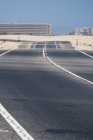 Autostrada nel deserto di Fuerteventura con edifici cittadini su sfondo sfocato, Isole Canarie — Foto stock