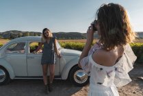 Стильна жінка фотографує друга в сільській місцевості з фотоапаратом — стокове фото
