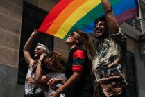 Groupe d'amis avec un drapeau de fierté gay dans la ville de Madrid — Photo de stock