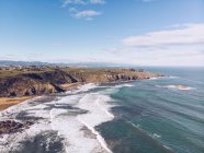 Dall'alto colpo di acqua di mare che ondeggia vicino alla costa rocciosa nelle Asturie, Spagna — Foto stock