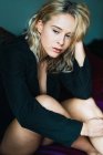 Jeune femme blonde sensuelle posant sur le lit — Photo de stock