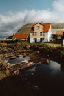 Maisons de village traditionnelles confortables sur les collines et la rivière sur l'île de Feroe — Photo de stock