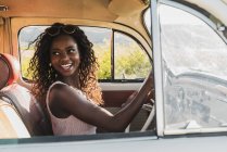 Красива усміхнена афроамериканська жінка за кермом автомобіля — стокове фото
