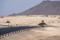 Strada con cartello e montagne nel deserto di Fuerteventura, Isole Canarie — Foto stock