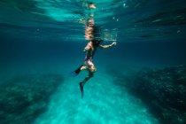 Menino irreconhecível snorkeling em água do mar escuro — Fotografia de Stock