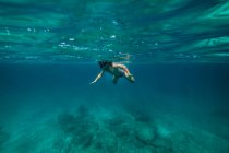 Unerkennbarer Junge schnorchelt im dunklen Meerwasser — Stockfoto