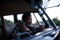 Beautiful afro man enjoys the trip in her vintage van with some friends — Stock Photo