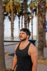 Portrait of bearded active man in sportswear standing among palm trees — Stock Photo