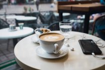 Taza de café con teléfono móvil - foto de stock