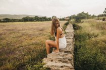 Young woman in overall in summer nature — Stock Photo