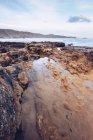 Calma acqua di mare vicino alla piccola baia vicino alla costa rocciosa in una giornata di sole nelle Asturie, Spagna — Foto stock