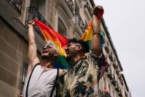 Casal meninos com gay orgulho bandeira no o rua de madri cidade — Fotografia de Stock