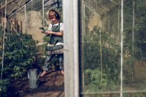 Boy listening to music in greenhouse — Stock Photo