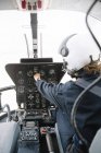 Focused female pilot sitting and operating in helicopter — Stock Photo