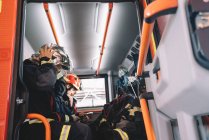 Pompiers travaillant à l'intérieur d'un véhicule d'urgence. — Photo de stock