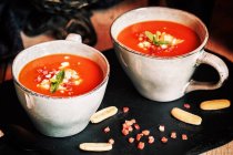 Tomaten Gazpacho serviert mit Ei und Schinken in Tassen auf Schiefer — Stockfoto