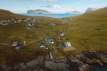 Veduta aerea di un piccolo villaggio immerso nel verde delle colline sulle isole Feroe — Foto stock