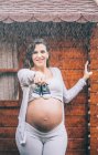 Bella donna incinta in posa sotto la pioggia — Foto stock