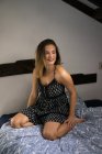 Verträumte attraktive Frau auf dem Bett — Stockfoto