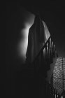 Человек, замаскированный под призрака на Хэллоуин в темной комнате — стоковое фото