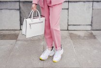 Close-up of stylish model in sneakers and pink suit — Stock Photo