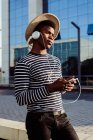 Чорний чоловік в навушниках за допомогою смартфона — стокове фото
