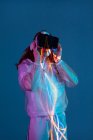 Woman using VR glasses on background with neon light — Stock Photo