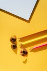 Back to school, Color pencil and shavings from sharpening on yellow background — Stock Photo
