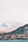 Пейзаж засніжених гір з маленьким містом на березі і кораблями в холодній гавані — стокове фото