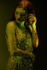 Sensual mulher elegante posando em luz quente no quarto escuro — Fotografia de Stock