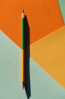Двокольоровий олівець, на світло-блакитному та помаранчевому геометричному фоні, назад до концепції школи — стокове фото