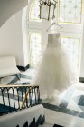 Вид на платье невесты, висящее на лампе — стоковое фото