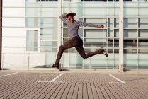 Стильний чорний чоловік стрибає на вулиці — стокове фото