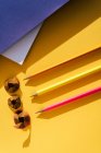 De volta à escola, lápis de cor e aparas de afiar no fundo amarelo e azul — Fotografia de Stock