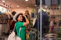 Cheerful woman choosing clothing in shop — Stock Photo