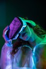 Woman wearing VR glasses in neon light — Stock Photo