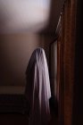 Pessoa disfarçada de fantasma para o Halloween andando em casa — Fotografia de Stock