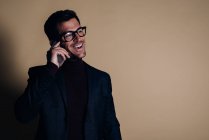 Joven hombre de negocios en un estudio hablando por teléfono móvil - foto de stock