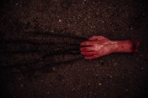 Main coupée sanglante traînant sur le sol — Photo de stock