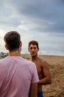 Due giovani atleti che parlano in spiaggia — Foto stock