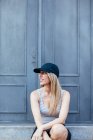 Blondes Mädchen mit Mütze posiert auf der Straße — Stockfoto