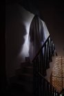 Persona disfrazada de fantasma para Halloween en habitación oscura - foto de stock