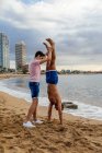 Two athletes do a handstand on the beach — Stock Photo
