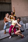 Gruppe junger Leute in trendigen Outfits lachen und machen Selfie, während sie sich auf der Straße der Stadt amüsieren — Stockfoto