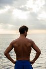 Joven atleta posando junto al mar - foto de stock