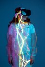 Woman in VR glasses standing in neon light stripes — Stock Photo