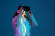 Woman using VR glasses in neon light stripes — Stock Photo